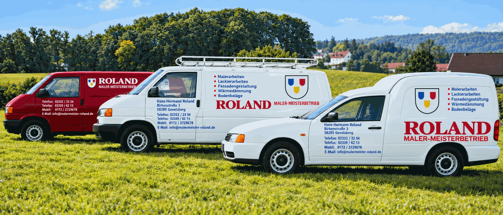 Drei Firmenfahrzeuge des Malerbetriebs Roland auf einer Wiese