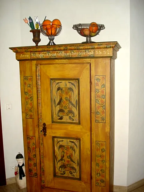 Heller Wandanstrich hinter einem bemalten Bauernschrank