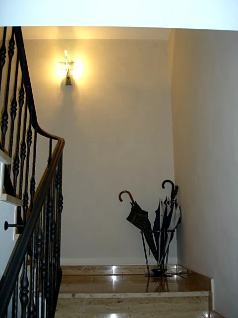 Treppenhaus mit hellem Wandanstrich und Wandleuchte